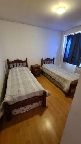 2 camas en una habitación con suelo de madera en LO DE SUSANA en San Martín de los Andes