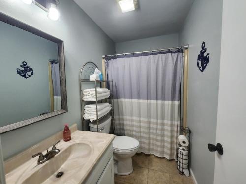 een badkamer met een wastafel, een toilet en een spiegel bij Lakefront condo with a VIEW Osage Beach in Osage Beach