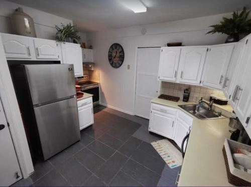a kitchen with white cabinets and a stainless steel refrigerator at Prime location! 4 bedroom house located right next to the casino and the falls in Niagara Falls