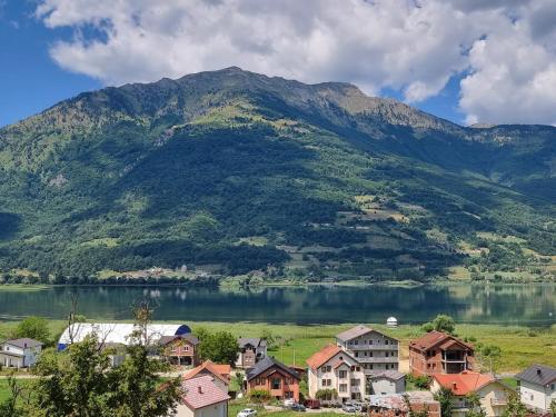 a village in front of a mountain with a lake at Eka's Village in Plav