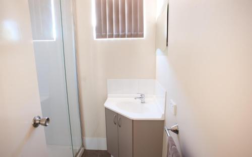 a white bathroom with a sink and a shower at Tasman Holiday Parks - Kalbarri in Kalbarri