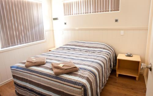 1 dormitorio con 1 cama con 2 toallas en Tasman Holiday Parks - Kalbarri, en Kalbarri