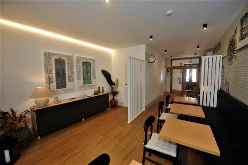 a dining room with tables and chairs and a clock on the wall at Angra Heritage - City Center Hostel in Angra do Heroísmo