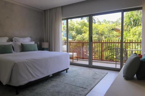 a bedroom with a large bed and a balcony at île de Pipa - Ma Plage Hotel in Pipa