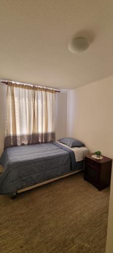 a bedroom with a bed with a curtain and a table at Departamento por Dia en Condominio in Arica