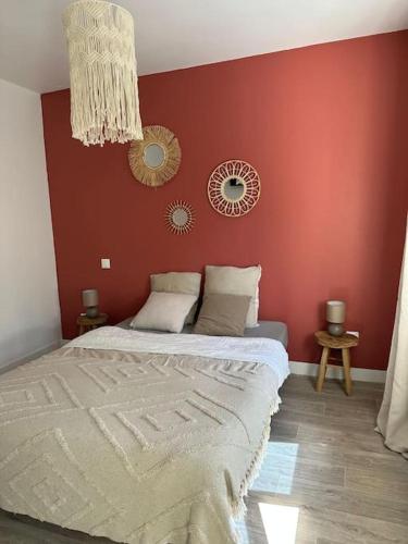 - une chambre dotée d'un lit avec un mur rouge dans l'établissement Appartement relaxant, à Amiens