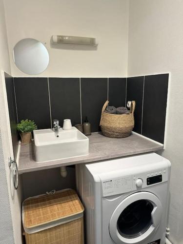 une salle de bain avec un lavabo et une machine à laver dans l'établissement Appartement relaxant, à Amiens