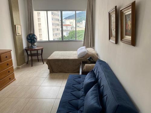 a living room with a blue couch and a window at M702-Centro in Rio de Janeiro