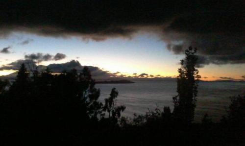 a sunset over a body of water with trees at Quilla Wasi - ISLA DEL SOL in Comunidad Yumani
