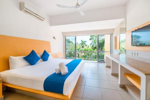 a bedroom with a large bed and a television at Hotel Ixzi Plus in Ixtapa