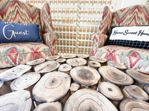 a room with a couch and a pile of logs at Dreamy Boho Remodeled Cottage with Mountain Views in Sparta