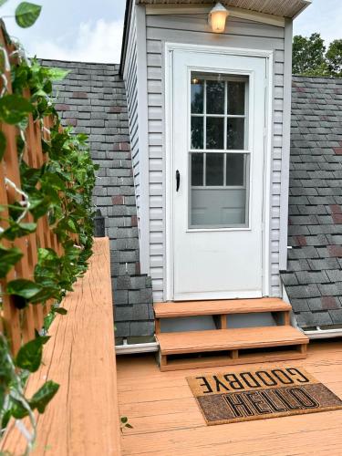 a white door on a house with a wooden deck at Dreamy Boho Remodeled Cottage with Mountain Views in Sparta