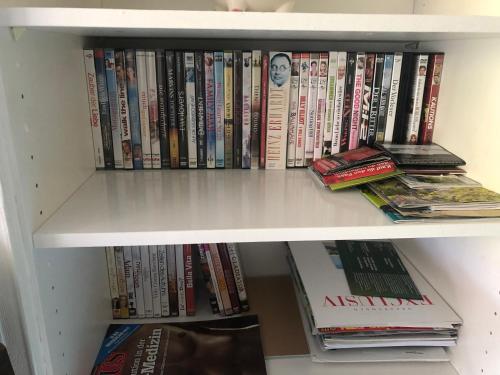 a white book shelf filled with lots of books at Laax with indoor and outside pool, sauna, 200 Meter to Ski lift , Fitnessroom, Tennis Place, Joyroom, Parkstadion Reserve in Laax