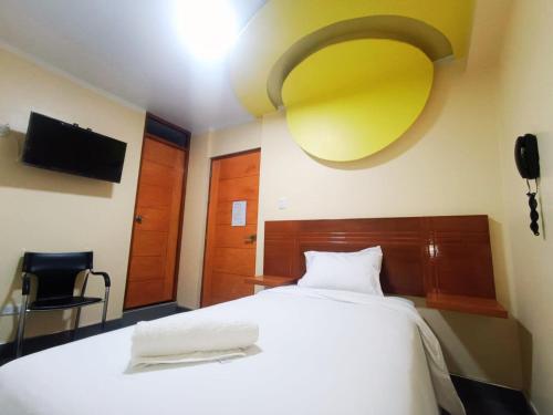 um quarto com uma cama branca e um tecto amarelo em ROYALS RESORT em Huaraz