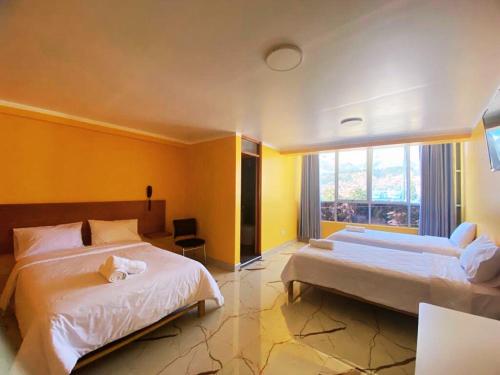 Habitación de hotel con 2 camas y ventana en ROYALS RESORT, en Huaraz