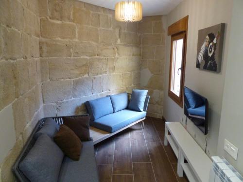 a living room with a blue couch and a chair at Apartamento Ábside de San Juan II in Estella