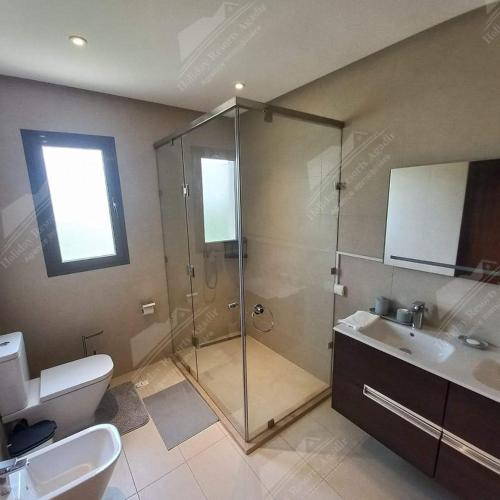 een badkamer met een douche, een toilet en een wastafel bij Sea Breeze Villa Taghazout Bay Amda golf & ocean view in Tamraght Ouzdar