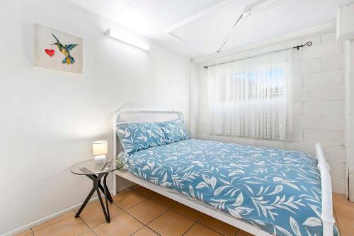 a small bedroom with a bed and a window at OceanViews on Burrum Whole in Burrum Heads