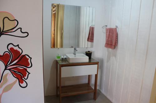 y baño con lavabo y espejo. en Casa das Ondas en Itapoa