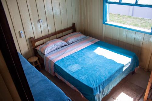 1 dormitorio con cama y ventana en Casa das Ondas en Itapoa