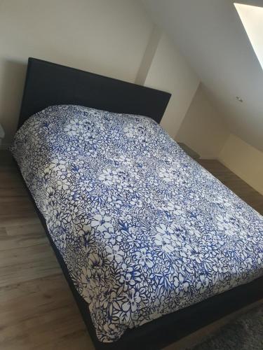 łóżko z niebiesko-białym kocem w obiekcie Aux portes de Lyon Jolie T3 Clim et PRIME Vidéo w mieście Givors