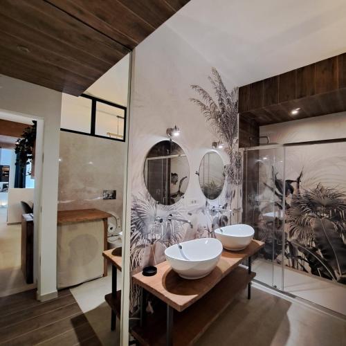 a bathroom with two sinks and mirrors on the wall at CAIETA Housing in Gaeta