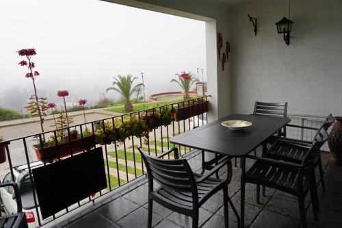 una mesa y sillas en un balcón con vistas en Departamento La Palmera, en Viña del Mar