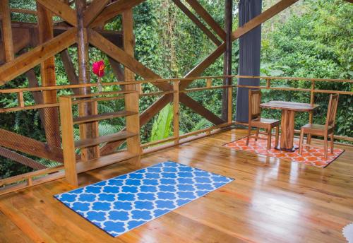 a room with a wooden floor and a table and a rug at Casa Cayuco Eco-Adventure Lodge in Bocas del Toro