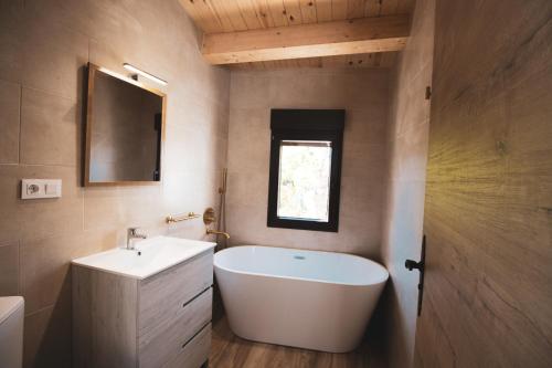 ein Badezimmer mit einer weißen Badewanne und einem Waschbecken in der Unterkunft CASA RURAL EL PADRONCILLO in Riópar