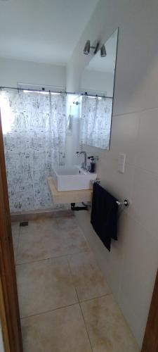 ein weißes Badezimmer mit einem Waschbecken und einem Spiegel in der Unterkunft Duplex cómodo y elegante zona alta de Mendoza in El Challao