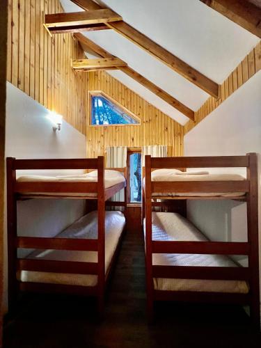 two bunk beds in a room with a window at Cabañas Bosque las Trancas in Las Trancas