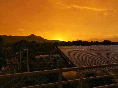 a sunset over a solar farm with the sun setting in the background at Casa Guiwa Hostel in Palomino