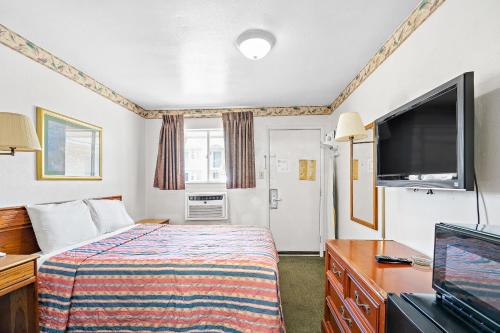 Cette chambre comprend un lit et une télévision à écran plat. dans l'établissement Friendship Inn Hotel, à Killeen