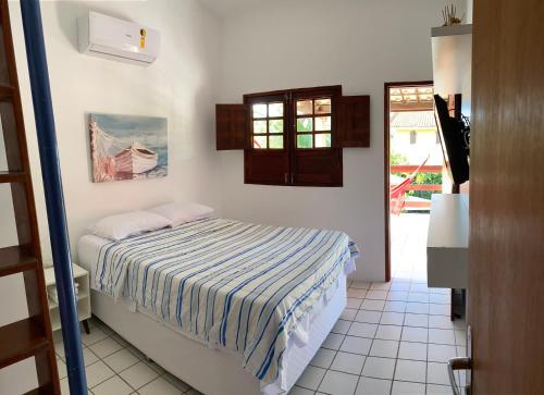 a bedroom with a bed and a door to a patio at Maravilhosa casa Ponta de Serrambi in Porto De Galinhas
