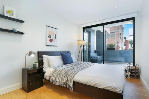 a bedroom with a bed and a sliding glass door at Urban Retreat in Surry Hills l 2 Bedroom Property with Parking in Sydney