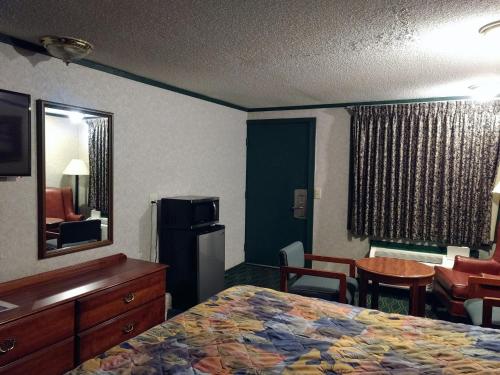 Habitación de hotel con cama y espejo en Kensington Inn - Howell, en Howell