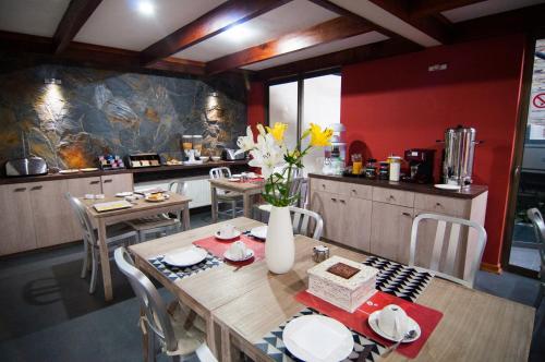 a kitchen with a wooden table with a vase of flowers at Hotel Stella Talca in Talca