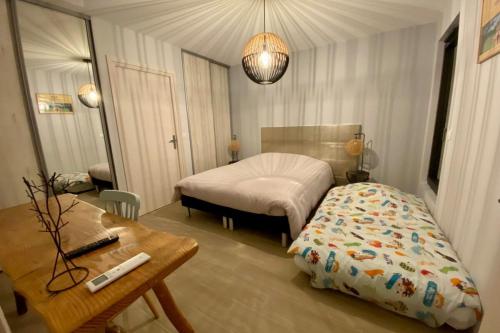 um quarto com uma cama, uma secretária e uma mesa em Le Cottage proche du Golf em Panazol