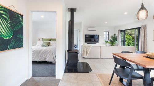 a kitchen and dining room with a wood stove at Matakana Village Central - Modern Holiday Home in Matakana