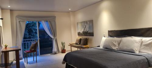 a bedroom with a bed and a door to a balcony at LOP Inn San Jose Aeropuerto - Costa Rica in Ciudad Cariari