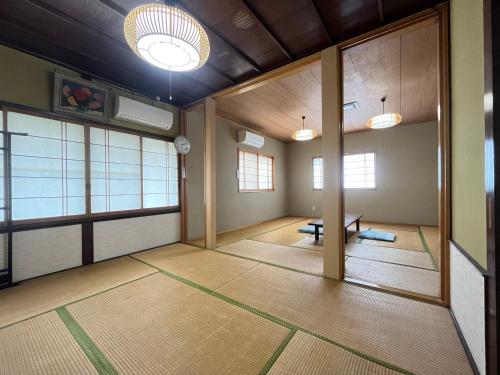 an empty room with a table and some windows at Uzueso in Tahara
