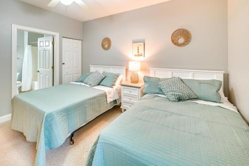a bedroom with two beds and a dresser with a mirror at Serene Myrtle Beach Condo with Community Pool! in Myrtle Beach