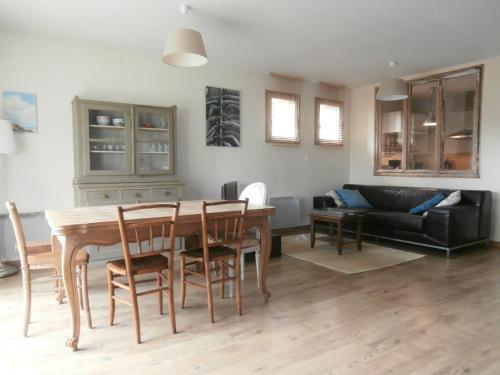 un salon avec une table, des chaises et un canapé dans l'établissement Cottage Les Quatre Saisons, à Giverny