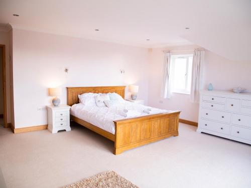 Un dormitorio con una gran cama de madera y una ventana en 2 Princes Cottages en Plymouth