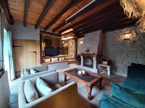 ein Wohnzimmer mit einem Sofa und einem Kamin in der Unterkunft Charming cottage in a farm with views in Gimnée