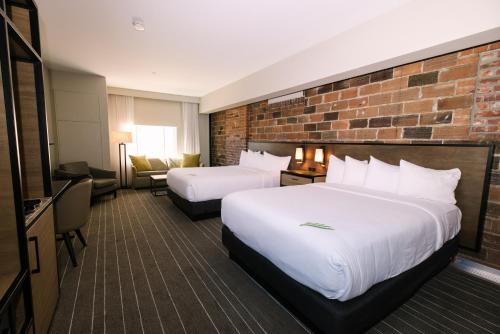 um quarto de hotel com duas camas e uma parede de tijolos em Hotel Windrow em Ellensburg