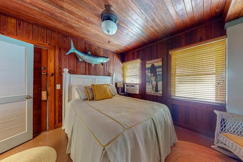 um quarto com uma cama num quarto com paredes de madeira em The Wee Cottage em Anna Maria