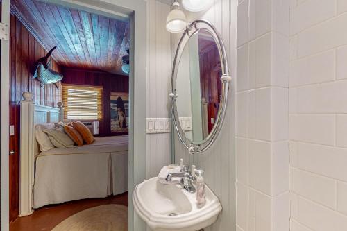 1 dormitorio con 1 cama y baño con lavabo. en The Wee Cottage en Anna Maria