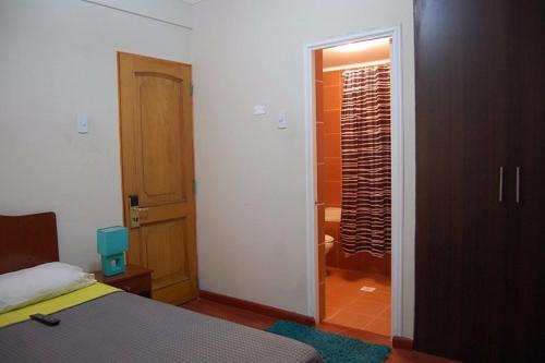a bedroom with a bed and a bathroom with a shower at Andina Hostel in Iquique