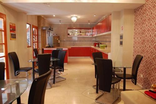 un restaurant avec des tables et des chaises et une cuisine dans l'établissement Andina Hostel, à Iquique